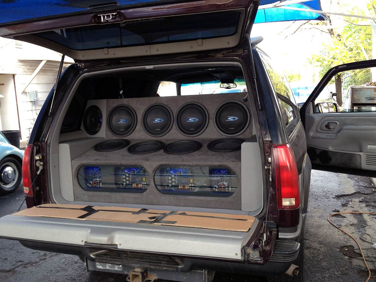 complete SUV car audio installation with subwoofers and amplifiers in rear cargo area